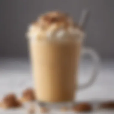 A close-up view of a frothy iced butter pecan latte adorned with crushed pecans and caramel drizzle