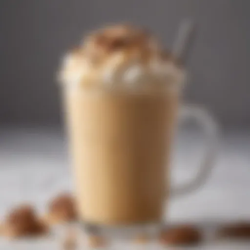 A close-up view of a frothy iced butter pecan latte adorned with crushed pecans and caramel drizzle